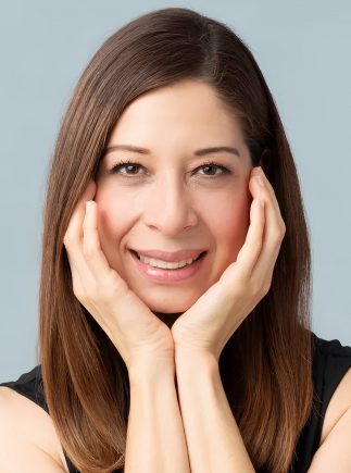 Attractive woman in her 40s feeling happy and smiling in a studio against a purple background